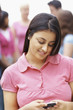 Happy Asian teenage girl text messaging on the mobile phone