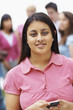 Asian teenage girl text messaging on the mobile phone