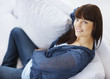 Foto: Happy beautiful young female sitting on the sofa Happy beautiful young female sitting on the sofa