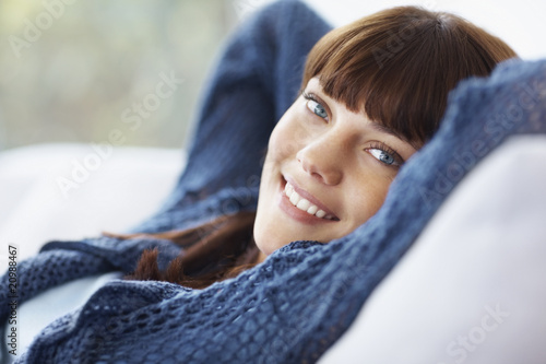 Foto: Closeup of a happy pretty woman relaxing on the couch Closeup of a happy pretty woman relaxing on the couch