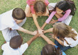Top view of kids sitting in a circle and playing on grass