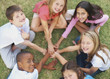 Happy little kids playing in a circle on grass