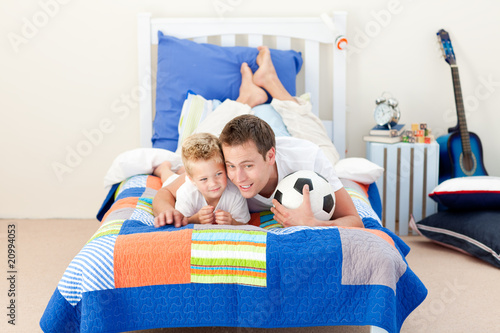 Photo: Cheerful father and his son watching a football match Cheerful father and his son watching a football match