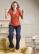 Teenage girl jumping on sofa