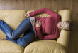 Woman laying on sofa wearing sleep mask