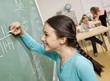 Student writing on blackboard