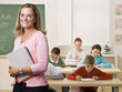 Teacher standing with notebook in classroom
