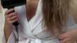 Video: Pretty woman using a blow-dryer sitting on bed Pretty woman using a blow-dryer sitting on bed