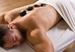 Man receiving hot stone therapy massage