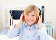 Happy boy listening music sitting on bed