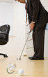 Photo: Businessman putting golf ball in office Businessman putting golf ball in office