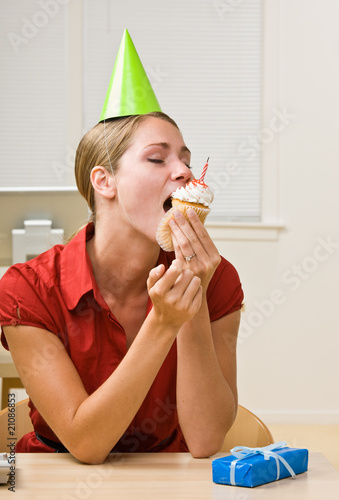 Photo: Businesswoman eating birthday cupcake Businesswoman eating birthday cupcake