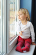 girl sits at  window