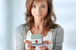 Woman holding euros bills and house model