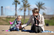 little daughter and mother playing on the sand little daughter and mother playing on the sand