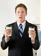 Foto: Businessman holding paper coffee cups Businessman holding paper coffee cups