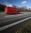 Red delivery/cargo van going fast on a highway