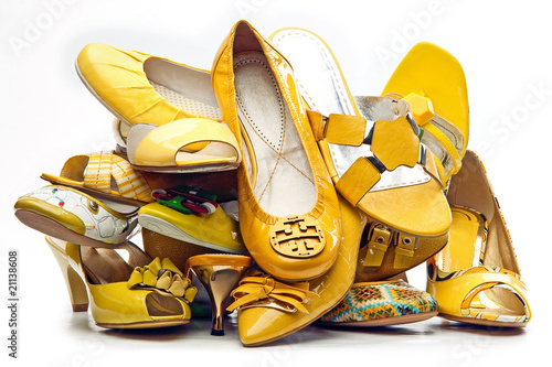 Photo: Pile of female yellow shoes isolated on white background Pile of female yellow shoes isolated on white background