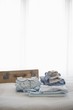 Childrens clothes folded on bed next to suitcase