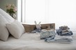 Childrens clothes folded on bed next to suitcase
