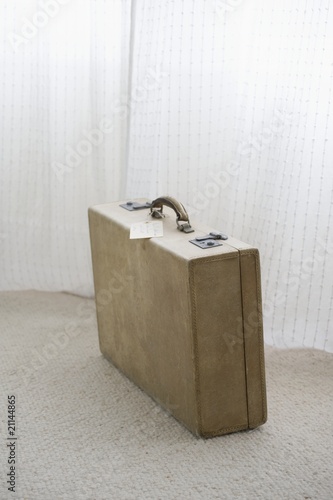 Photo: Old fashioned suitcase with luggage tag Old fashioned suitcase with luggage tag