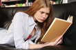 Foto: Teenager, Mädchen liest ein Buch auf dem Sofa Teenager, Mädchen liest ein Buch auf dem Sofa