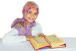 Little girl reads Koran and smiles