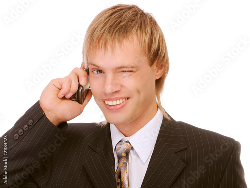 Photo: Young businessman winks and speaks by phone Young businessman winks and speaks by phone