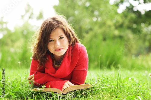 Foto: Pretty smiling girl reading book outdoor Pretty smiling girl reading book outdoor