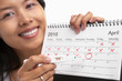 Happy woman with positive pregnancy test and calendar.