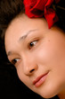 Beautiful young asian girl face with a red rose