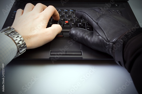 Photo: Businessman and hacker hands on laptop keyboard Businessman and hacker hands on laptop keyboard