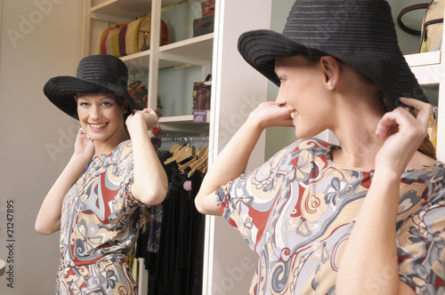 Foto: Portrait of a woman trying a hat Portrait of a woman trying a hat