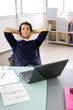 Jeune homme détendu devant ordinateur portable au bureau