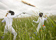 Two girls fencing in a field.