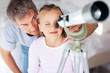 Foto: Adorable girl looking at sky through telescope with her father Adorable girl looking at sky through telescope with her father