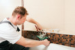 Installateur bringt Mischbatterie im Bad an