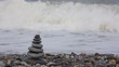 stone stack on pebble beach, waving sea in background