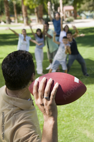 Photo: man throwing football to group of people back view. man throwing football to group of people back view.