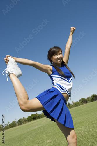 Photo: teenage cheerleader stretching on lawn teenage cheerleader stretching on lawn