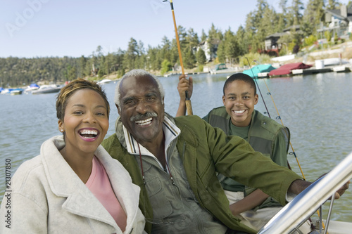 Photo: three generation family on fishing trip smiling (portrait) three generation family on fishing trip smiling (portrait)