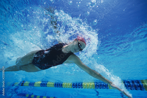 Photo: female swimmer racing underwater in pool female swimmer racing underwater in pool