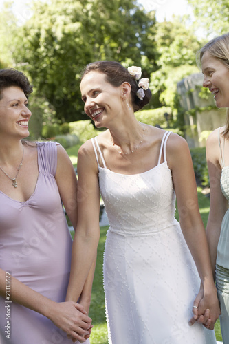 Photo: bride with two women in garden holding hands smiling portrait bride with two women in garden holding hands smiling portrait