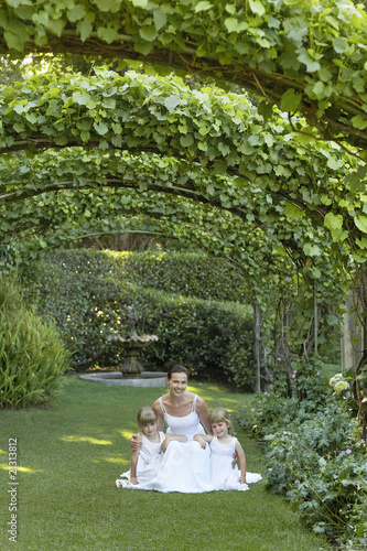 Photo: two young girls and mid adult bride squatting under ivy arches portrait two young girls and mid adult bride squatting under ivy arches portrait