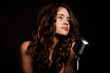 Beautiful brunette girl singer singing with vintage microphone