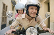Man and woman riding scooter