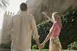 Man and woman holding hands using digital camera