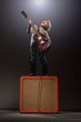 Boy playing electric guitar standing on speaker
