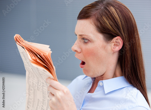 Astonished businesswoman reading newspaper Astonished businesswoman reading newspaper