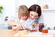 Brunette mother helping her daughter prepare the breakfast